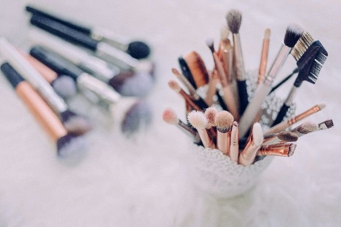 A delicate arrangement of various makeup brushes in a holder, representing the essential tools needed for tackling makeup stain removal on fabrics and furniture.