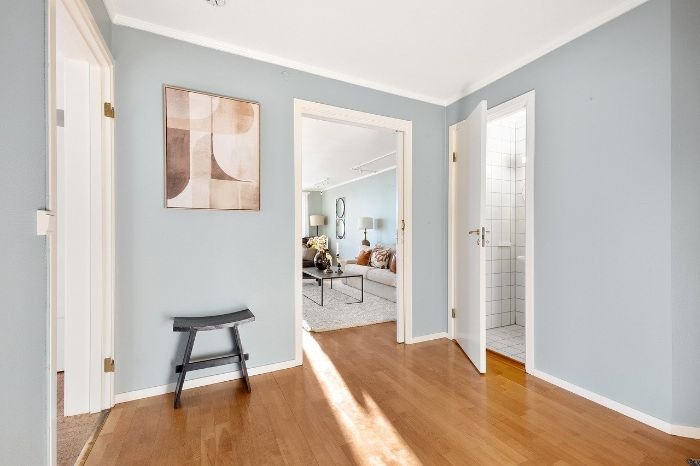 Sunlit corridor leading to various rooms, highlighting the pristine condition expected from an end-of-tenancy cleaning in shared living spaces.