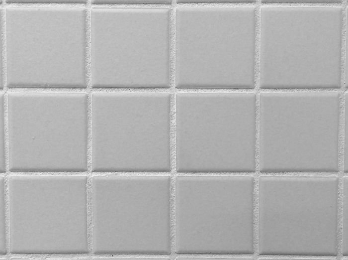 Close-up view of clean white tiles with immaculate grout lines, highlighting the importance of proper maintenance for a hygienic and aesthetically pleasing bathroom.
