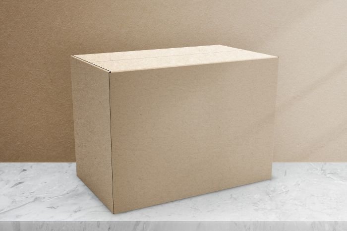 A plain cardboard box on a marble surface against a neutral backdrop, symbolizing organized and efficient packing strategies for moving.